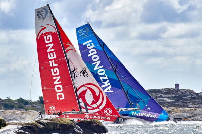 Dinghies racing around a course mark during a competitive sailing regatta