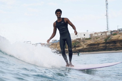 Surfer wearing a Nyord Solu Long Jane sleeveless wetsuit on a summer beach